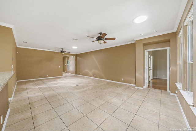 tiled empty room with ceiling fan and ornamental molding