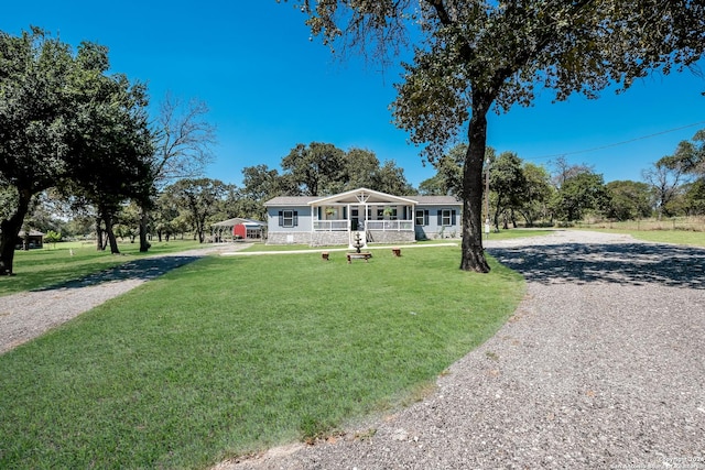 1350 Blue Quail Dr, Lytle, TX 78052 - view of front facade featuring gravel driveway, a front yard, and covered porch