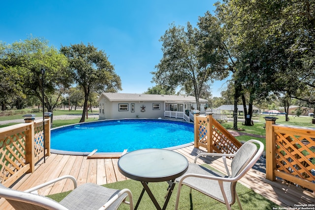 view of pool featuring a wooden deck and a yard