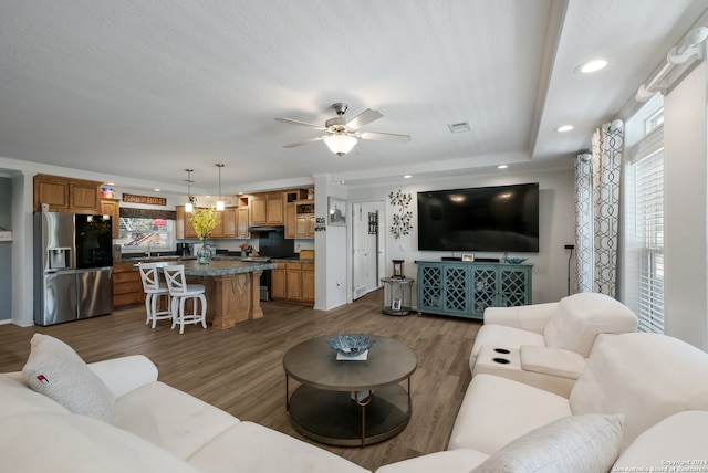 living room featuring ceiling fan and dark hardwood / wood-style flooring