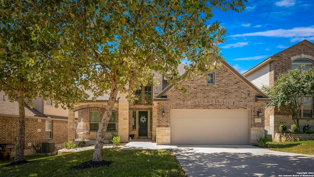 view of front of property with cooling unit, a garage, and a front lawn