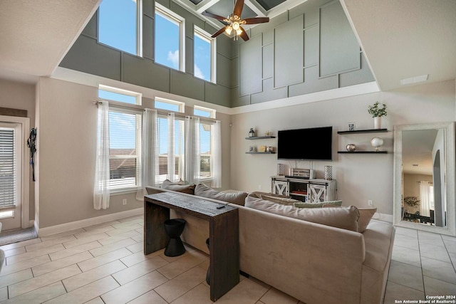 tiled living room with a towering ceiling and ceiling fan