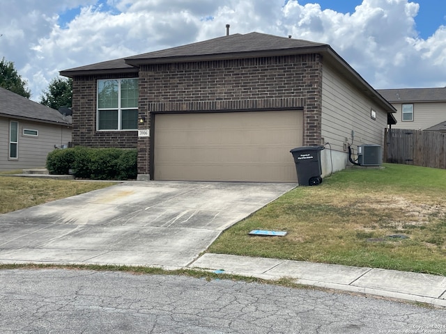 view of front of house featuring a garage, a front lawn, and central air condition unit