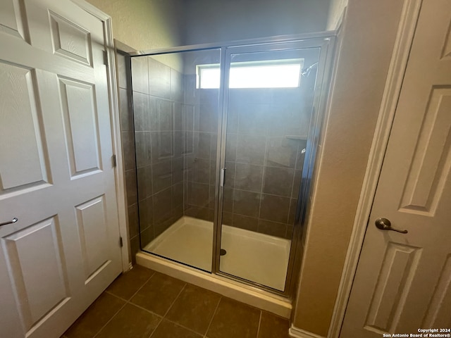 bathroom featuring tile patterned floors and a shower with door