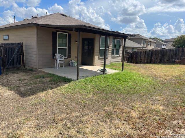 back of property featuring a lawn and a patio