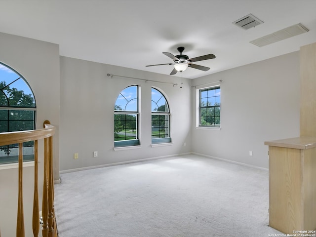 carpeted spare room with ceiling fan