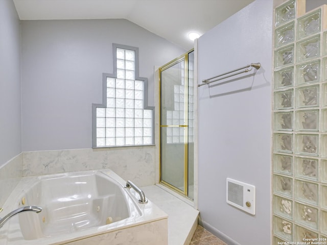 bathroom featuring tile patterned flooring, shower with separate bathtub, heating unit, and vaulted ceiling