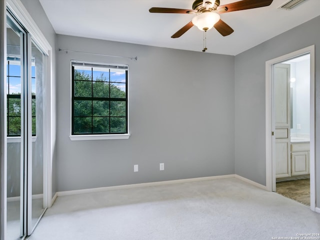 carpeted spare room with ceiling fan