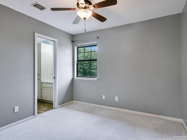 unfurnished bedroom with light carpet, ensuite bathroom, and ceiling fan