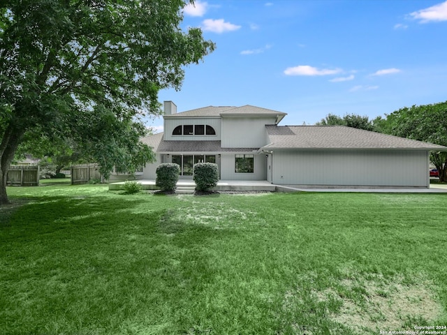 rear view of property with a lawn and a patio