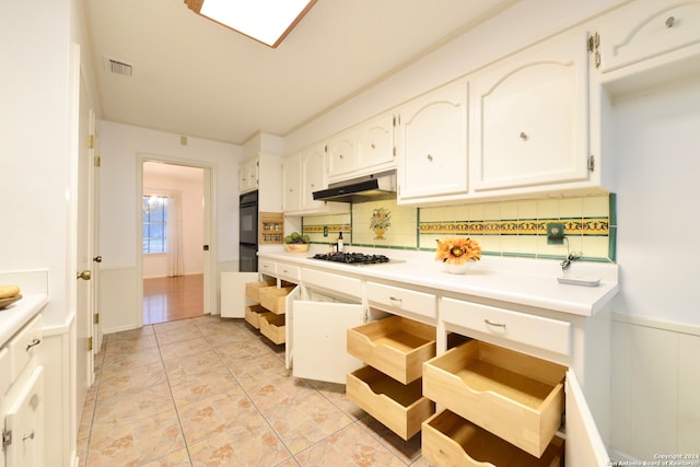 kitchen with white cabinetry, decorative backsplash, double oven, and gas stovetop