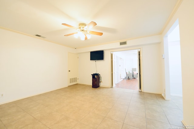 empty room featuring crown molding, light tile patterned flooring, and ceiling fan