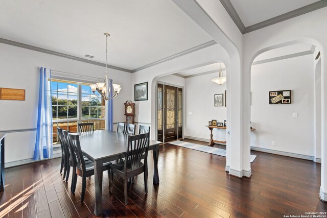 dining space with dark hardwood / wood-style floors, a chandelier, and ornamental molding