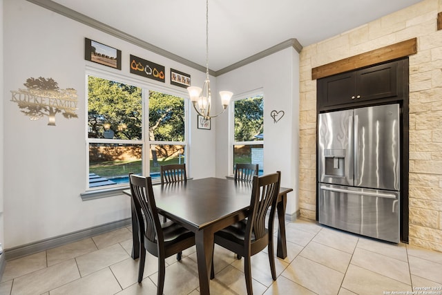 dining area with light tile patterned floors, a notable chandelier, and ornamental molding