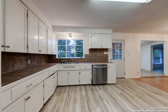 kitchen featuring dishwasher, light hardwood / wood-style flooring, tasteful backsplash, sink, and white cabinets