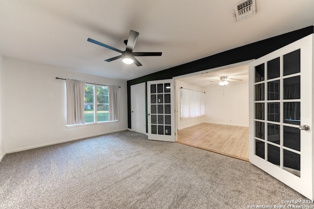 carpeted empty room with french doors and ceiling fan