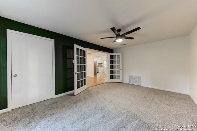 empty room featuring carpet flooring, ceiling fan, and french doors