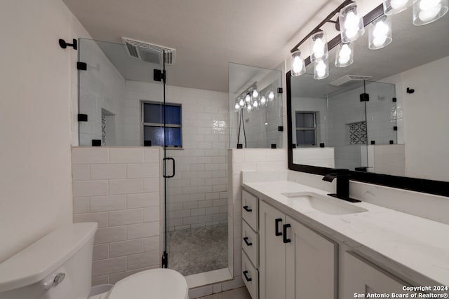 bathroom featuring an enclosed shower, toilet, tile walls, vanity, and a textured ceiling