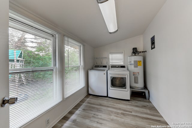 laundry area with washer and dryer, light hardwood / wood-style floors, and water heater