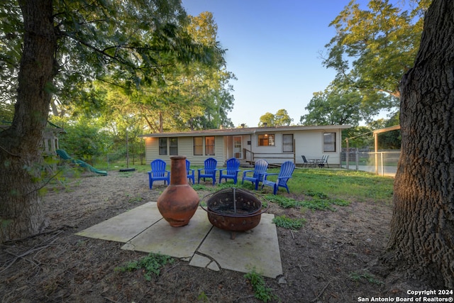 rear view of house featuring a fire pit and a patio area