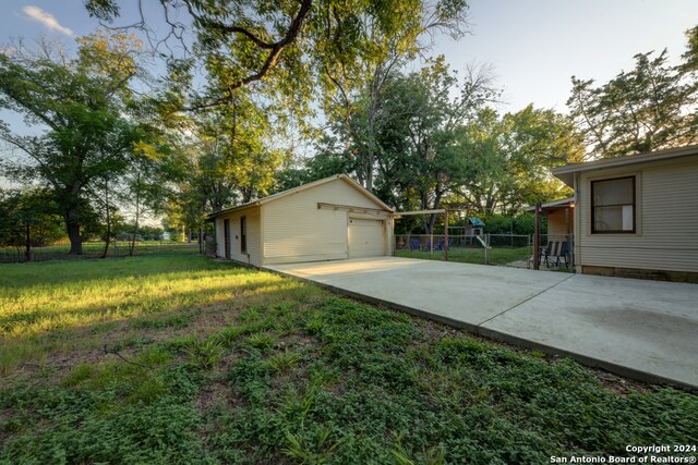 view of yard with a garage and an outbuilding