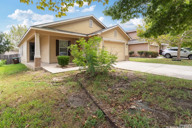 view of front of property with a porch, a garage, and a front lawn