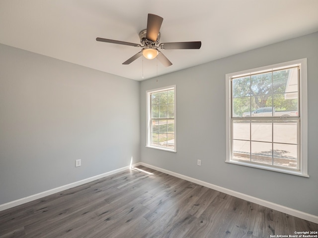 empty room with ceiling fan and dark hardwood / wood-style floors