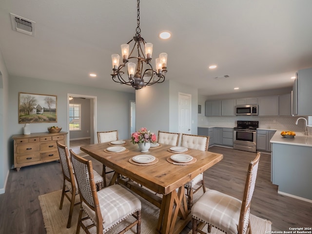 dining area featuring a chandelier, sink, and dark hardwood / wood-style floors