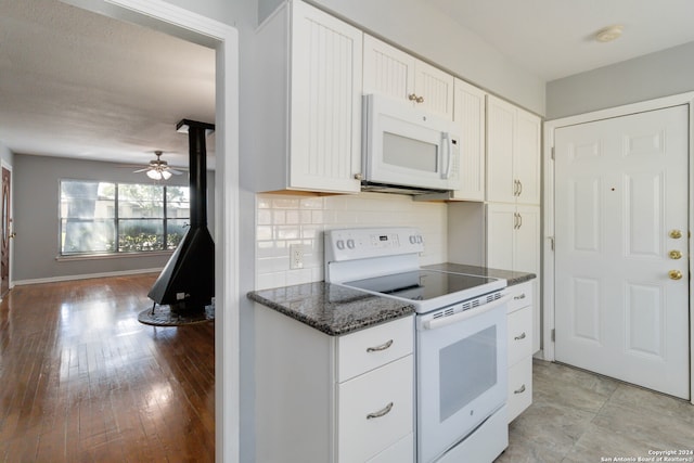 kitchen with light wood-type flooring, white appliances, ceiling fan, decorative backsplash, and white cabinets