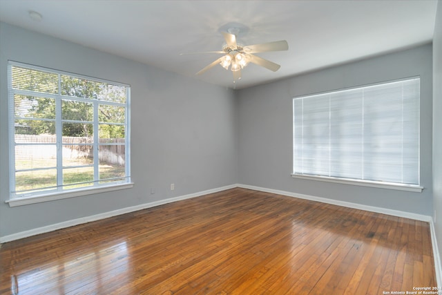 spare room with dark hardwood / wood-style flooring and ceiling fan