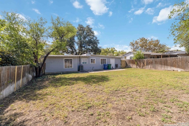 rear view of property with a patio area, a yard, and central air condition unit