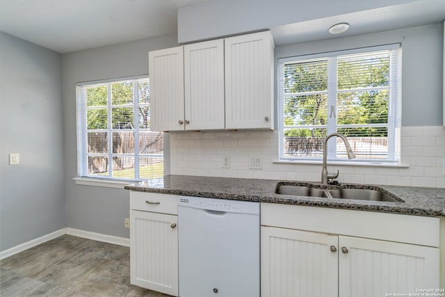 kitchen with white dishwasher, a wealth of natural light, sink, and white cabinets