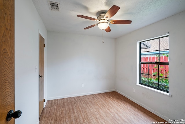 unfurnished room with ceiling fan, a textured ceiling, and light hardwood / wood-style flooring