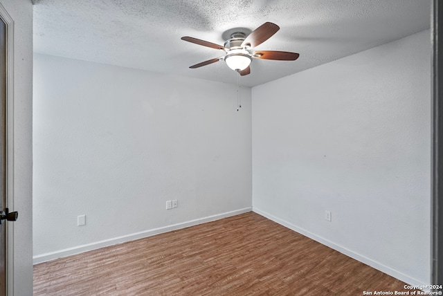 empty room with hardwood / wood-style floors, ceiling fan, and a textured ceiling