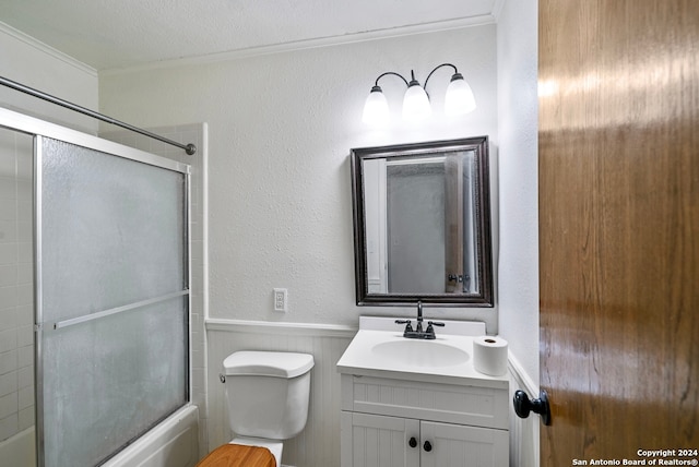 full bathroom featuring bath / shower combo with glass door, a textured ceiling, vanity, crown molding, and toilet