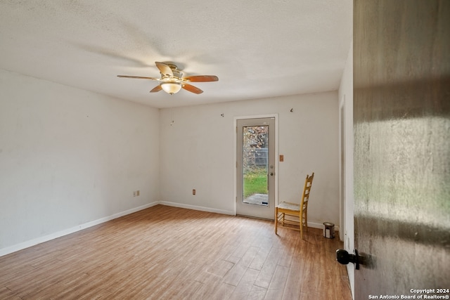 spare room with a textured ceiling, light wood-type flooring, and ceiling fan