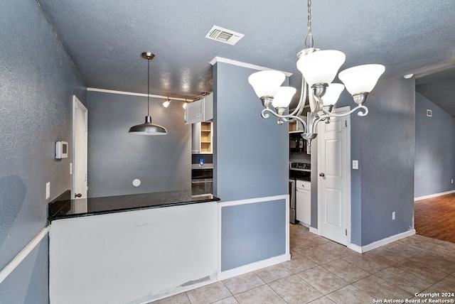 kitchen with pendant lighting, ornamental molding, a notable chandelier, stainless steel range oven, and white cabinetry