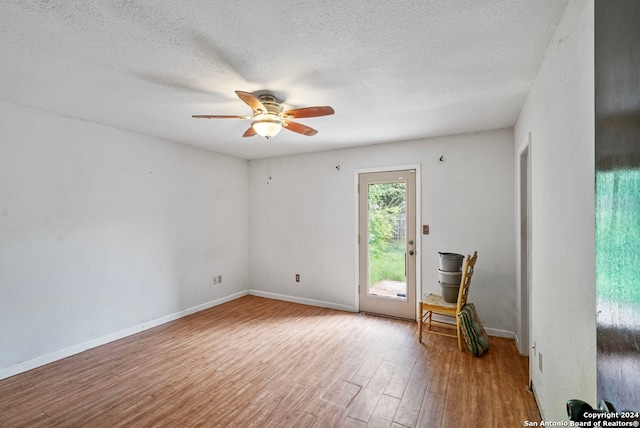 unfurnished room featuring ceiling fan, wood-type flooring, and a textured ceiling