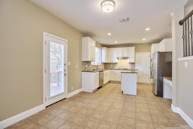 kitchen featuring a center island, tasteful backsplash, a sink, appliances with stainless steel finishes, and visible vents