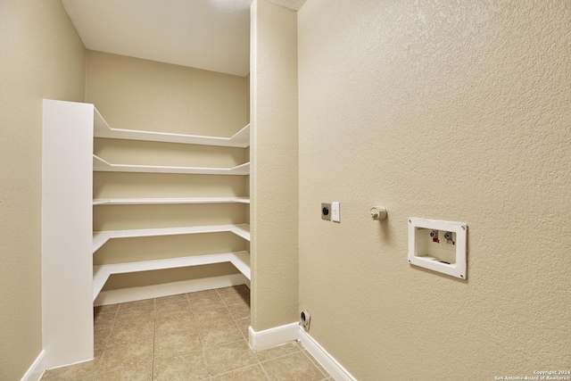 interior space featuring hookup for a washing machine, tile patterned floors, hookup for an electric dryer, baseboards, and laundry area