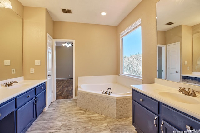 bathroom with vanity and tiled bath