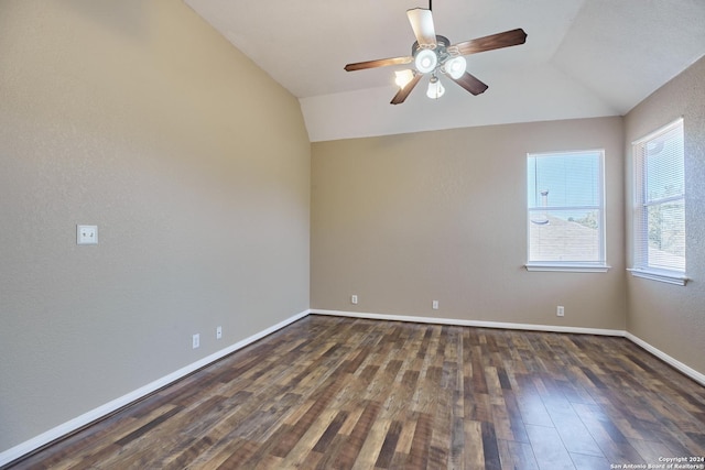 empty room with baseboards, vaulted ceiling, dark wood-style floors, and ceiling fan