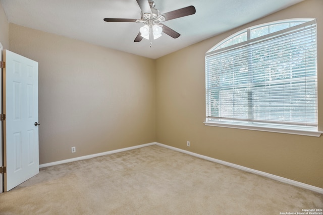 empty room with a healthy amount of sunlight, light carpet, and ceiling fan