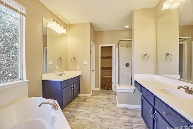 full bath with two vanities, baseboards, a sink, and a shower stall