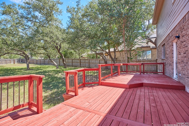 wooden deck featuring a lawn