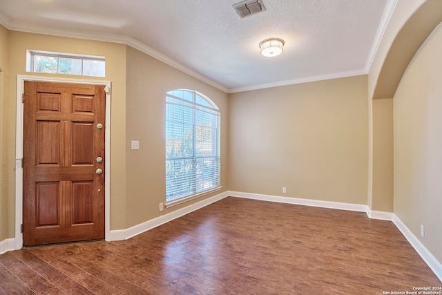 foyer featuring dark wood-type flooring, crown molding, and a textured ceiling