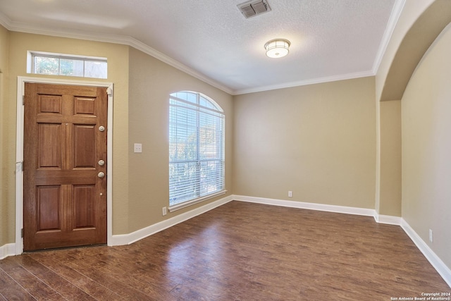 foyer entrance featuring baseboards, visible vents, ornamental molding, and dark wood finished floors