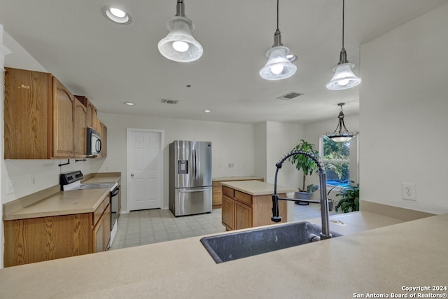 kitchen with decorative light fixtures, sink, stainless steel fridge, and electric stove