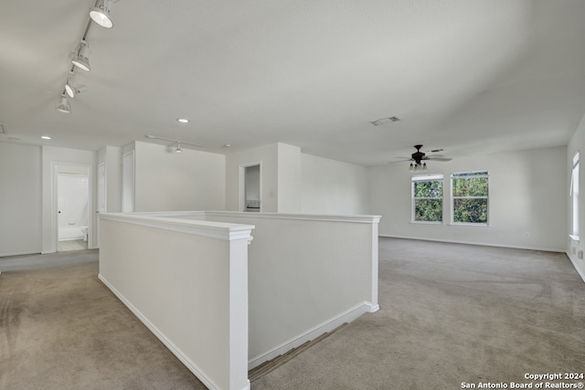 hall with light carpet and rail lighting