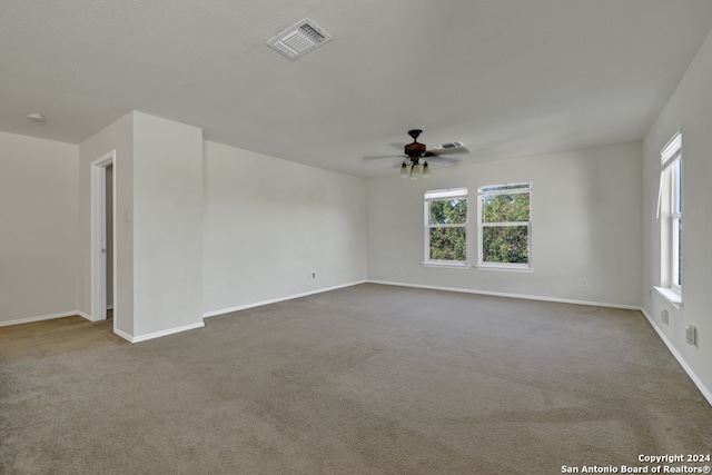 empty room featuring ceiling fan, carpet, and plenty of natural light